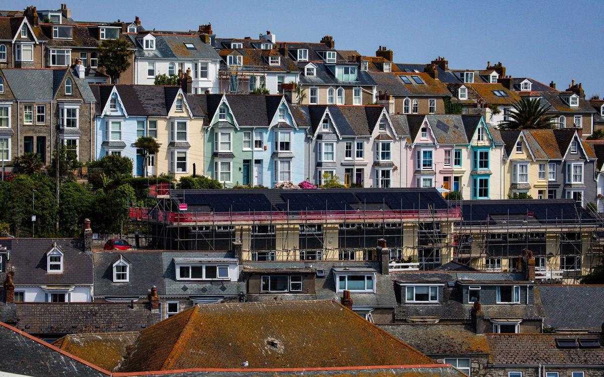 Scaffolded row of terraced houses on a coastal hillside